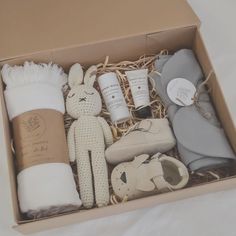 an open box containing baby items including a stuffed animal, diaper and other personal care products