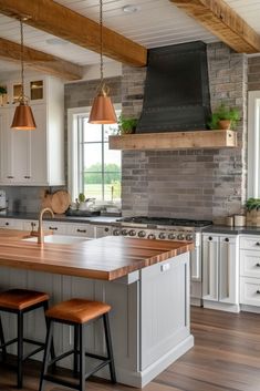 a kitchen with white cabinets and wooden counter tops next to an island in the middle