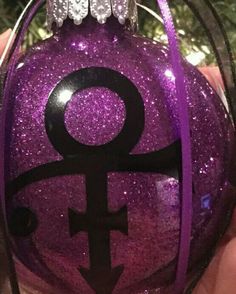 a purple ornament with an image of the female symbol on it