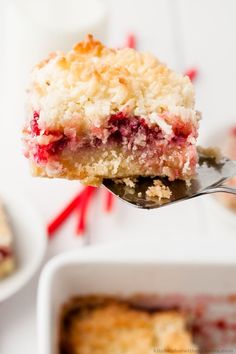 a piece of strawberry crumb cake being lifted from a white dish with a fork