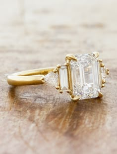 an engagement ring with a large diamond and two smaller baguettes on the side