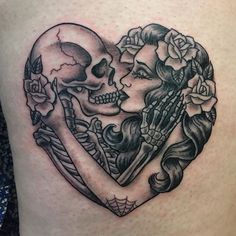 a couple of skulls in the shape of a heart tattoo on someone's thigh