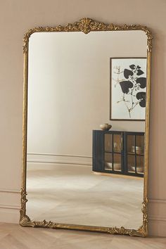 a large mirror sitting on top of a wooden floor