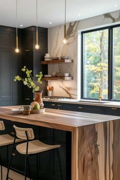 a kitchen with black cabinets and wooden counter tops, along with two bar stools