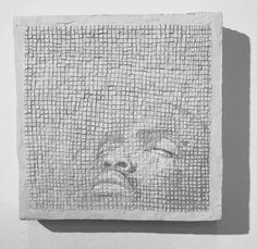 a black and white photo of a face on a wall