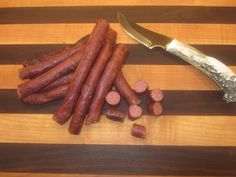 some sausages are on a cutting board next to a knife