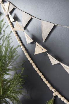 a plant is sitting next to a wall with some pennants hanging from it's sides