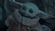 the child yoda is holding something in his hands