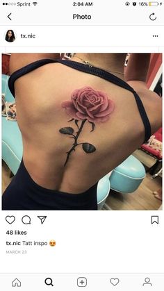 the back of a woman's stomach with a rose tattoo on her left side