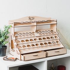 a wooden tool box sitting on top of a white table next to a potted plant