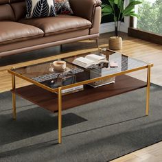 a living room with a couch, coffee table and books on the floor in front of it