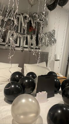 black and silver balloons are on the bed