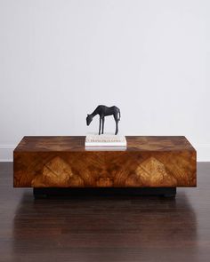 a wooden table topped with a horse figurine on top of a hard wood floor