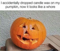 a carved pumpkin sitting on top of a table next to a cell phone with the caption, i accidentally dropped candle wax on my pumpkin, now it looks like a