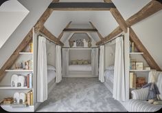 an attic bedroom with white walls and carpeted flooring, built in bookshelves