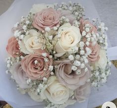 a bouquet of pink and white flowers sitting on top of a piece of paper