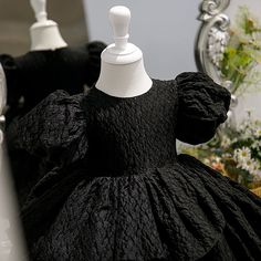 a mannequin wearing a black dress in front of a mirror