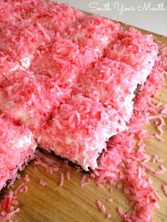 pink rice krispy kreme bars are cut into squares on a cutting board