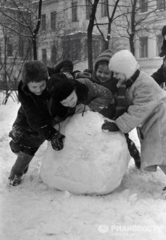 children building a snowman in the snow