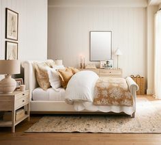 a white bed sitting next to a window on top of a wooden floor in a bedroom