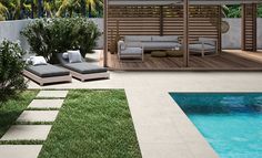 an outdoor living area with pool and lounge chairs