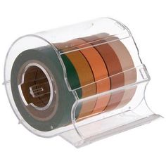 a roll of colored tape in a clear holder on a white background with clippings