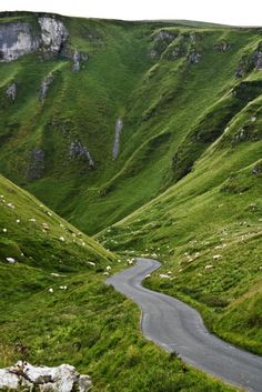 a winding road in the middle of green hills