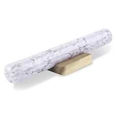 a white marble and wood object on a wooden stand