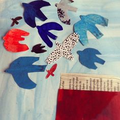 paper birds are flying in the air on top of a blue sheet with red, white and blue colors