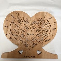 a wooden heart shaped puzzle with names on it