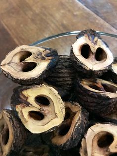 a glass bowl filled with cut up pieces of wood on top of a wooden floor