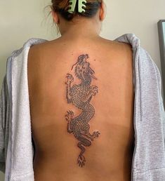 a woman with a dragon tattoo on her back