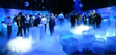 a group of people standing around ice cubes in the middle of a dark room