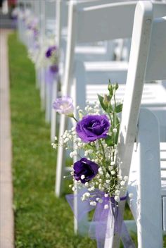 rows of white chairs with purple flowers and baby's breath in the back row