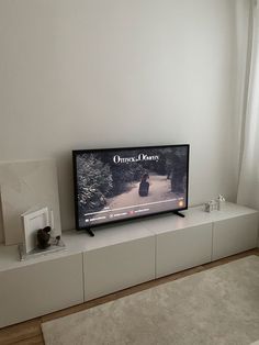 a flat screen tv sitting on top of a white shelf