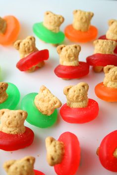 there are many cookies shaped like teddy bears on top of gummy balls and candy