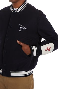 Golden Goose puts their signature stamp on old-school style with this wool varsity jacket detailed with logo embroidery and framed with striped ribbed trim. Front snap closure Blade collar Ribbed cuffs Front welt pockets 100% wool Dry clean Made in Italy Men's Designer Clothing Wool Varsity Jacket With Embroidered Logo And Baseball Collar, Classic Varsity Jacket With Embroidered Logo For Streetwear, Wool Varsity Jacket With Embroidered Logo, Wool Outerwear With Embroidered Logo And Baseball Collar, Wool Varsity Jacket With Embroidered Logo For Streetwear, Classic Wool Varsity Jacket With Baseball Collar, Classic Long Sleeve Varsity Jacket With Embroidered Logo, Collegiate Varsity Jacket With Embroidered Logo For Winter, Classic Navy Varsity Jacket For College