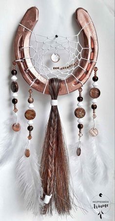 a dream catcher with feathers and beads hanging from it