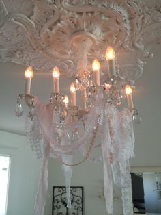 a chandelier hanging from the ceiling in a room with white walls and ceilings