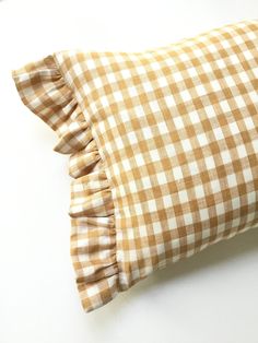 a brown and white gingham pillow with ruffles on the front side