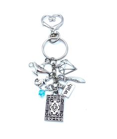 a metal key chain with various items attached to it's end and a heart on top