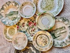 a pile of plates sitting on top of a white tablecloth covered floor next to a cup and saucer