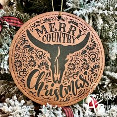 a christmas ornament hanging from a tree with the words merry country on it