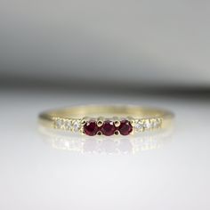 "A beautiful gemstone stacking ring, handmade in 14K Gold and set with Rubys and Diamonds. An ideal gift that is made to last a life time. Handmade by an inspired jewelry artist team with decades of experience in the craft of jewelry making. Each gemstone, each diamond is carefully picked. Using only the finest raw materials and the highest industry standard in manufacturing, design and finish. Ring Features: 3 x Natural Pink Ruby gemstones, 0.10 ct 6 x natural diamonds, 0.04 ct VS-E Ring width Yellow Gold Three Stone Promise Ring, Ruby Half Eternity Jewelry Gift, Stackable 14k Gold Ruby Ring For Promise, 14k Gold Stackable Ruby Promise Ring, Promise Stackable 14k Gold Ruby Ring, Fine Jewelry Ruby Half Eternity, Stackable Ruby Fine Jewelry, Ruby Stackable Jewelry For Promise, Stackable Gold Ruby Rings