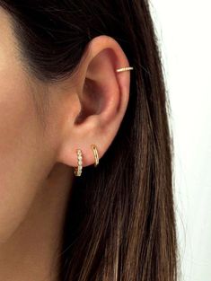 a close up of a person wearing a pair of ear piercings with diamonds on them