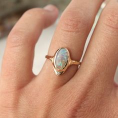 A long oval opal is bezel set in 14k gold  with  a star set  diamond at the base of the ring. Bezel Opal Ring, Opal Ring Designs, Star Wedding Ring, Vintage Opal Rings, Celestial Engagement Ring, Opal Wedding Ring Set, Star Setting, Opal Wedding Ring, Raw Opal Ring