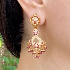 Featuring a pair of dainty danglers made in sterling silver with gold plating. The studded stones comprise ruby like red stones and freshwater pearls. The hanging beads are real rubies. The earrings close with a bombay screw. Temple Jewelry Chandelier Earrings With Pearl Drop, Gold Plated Pearl Drop Temple Earrings, Temple Jewelry Pearl Drop Dangle Earrings, Temple Jewelry Dangle Pearl Drop Earrings, Yellow Gold Temple Jewelry Earrings With Pearl Drop, Yellow Gold Pearl Drop Temple Earrings, Festive Gold-plated Jeweled Earrings, Gold Plated Pearl Earrings For Celebrations In Temple Style, Gold Plated Temple Style Pearl Earrings For Celebration