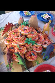 a table topped with lots of donuts covered in sprinkles and frosting