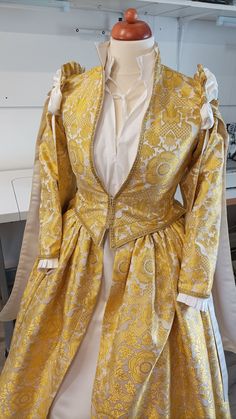 a yellow and white dress sitting on top of a table