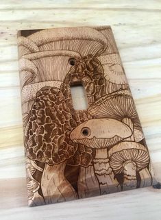 a decorative light switch cover with an image of mushrooms and fish in the woods on it